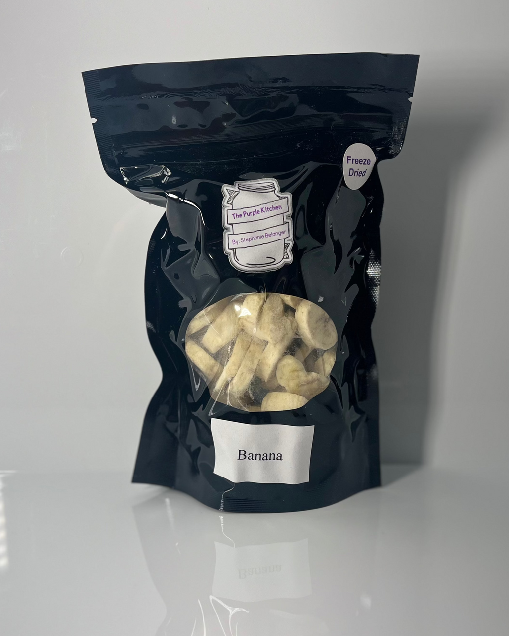 Black package of freeze dried bananas on a white background