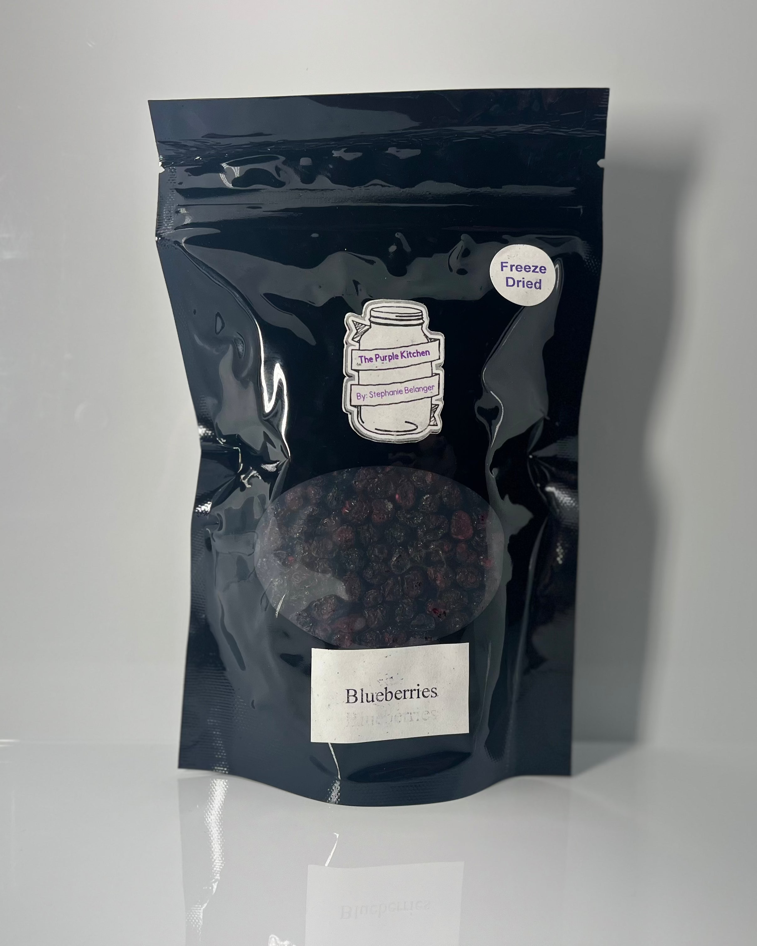 Black packaging of freeze dried blueberries with the Purple Kitchen label on a white background