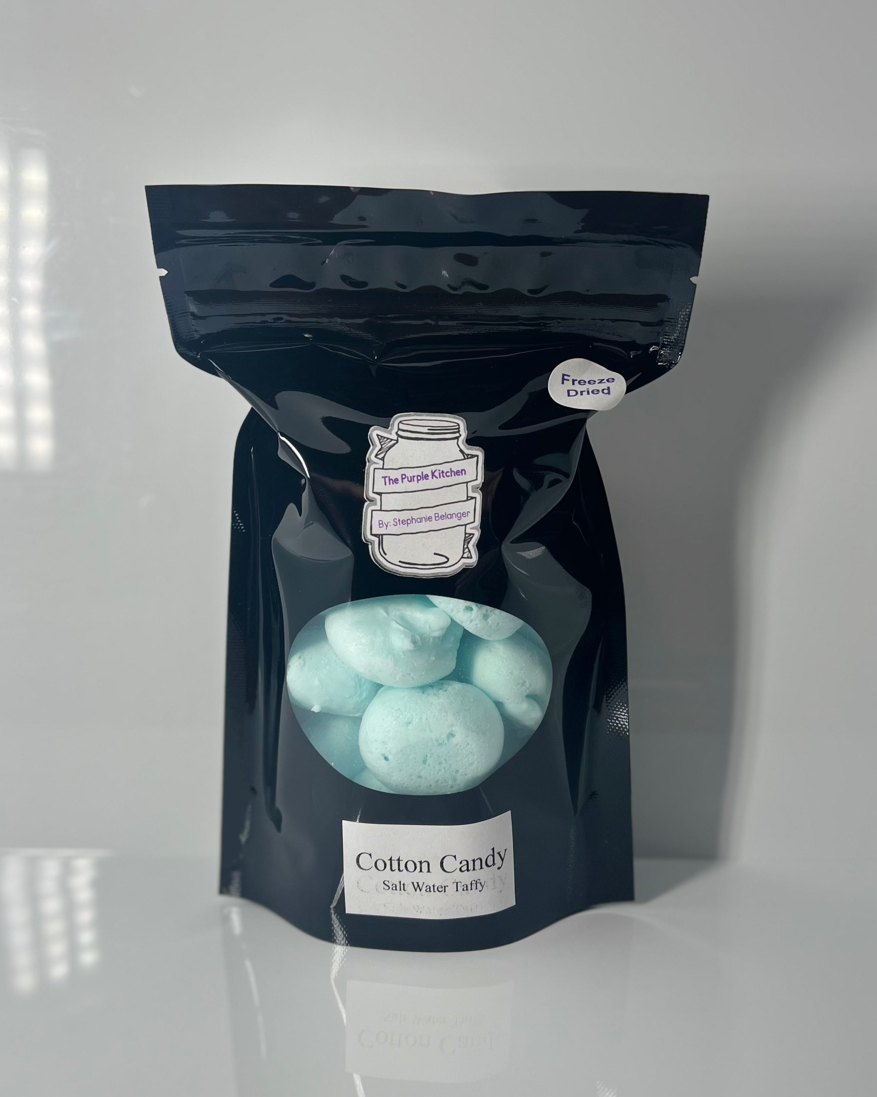 Black package of freeze dried salt water taffy on a white background 