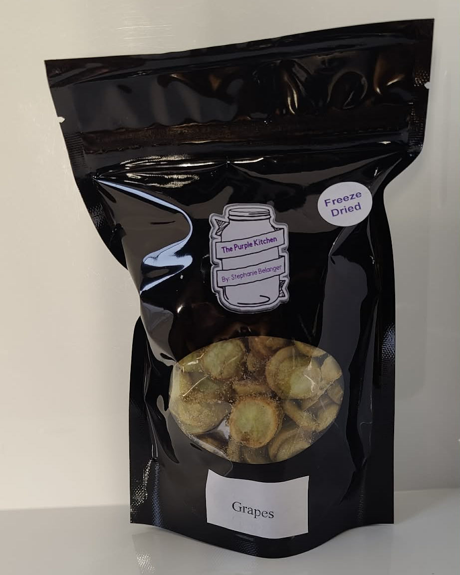Black packaging of freeze dried grapes on a white surface